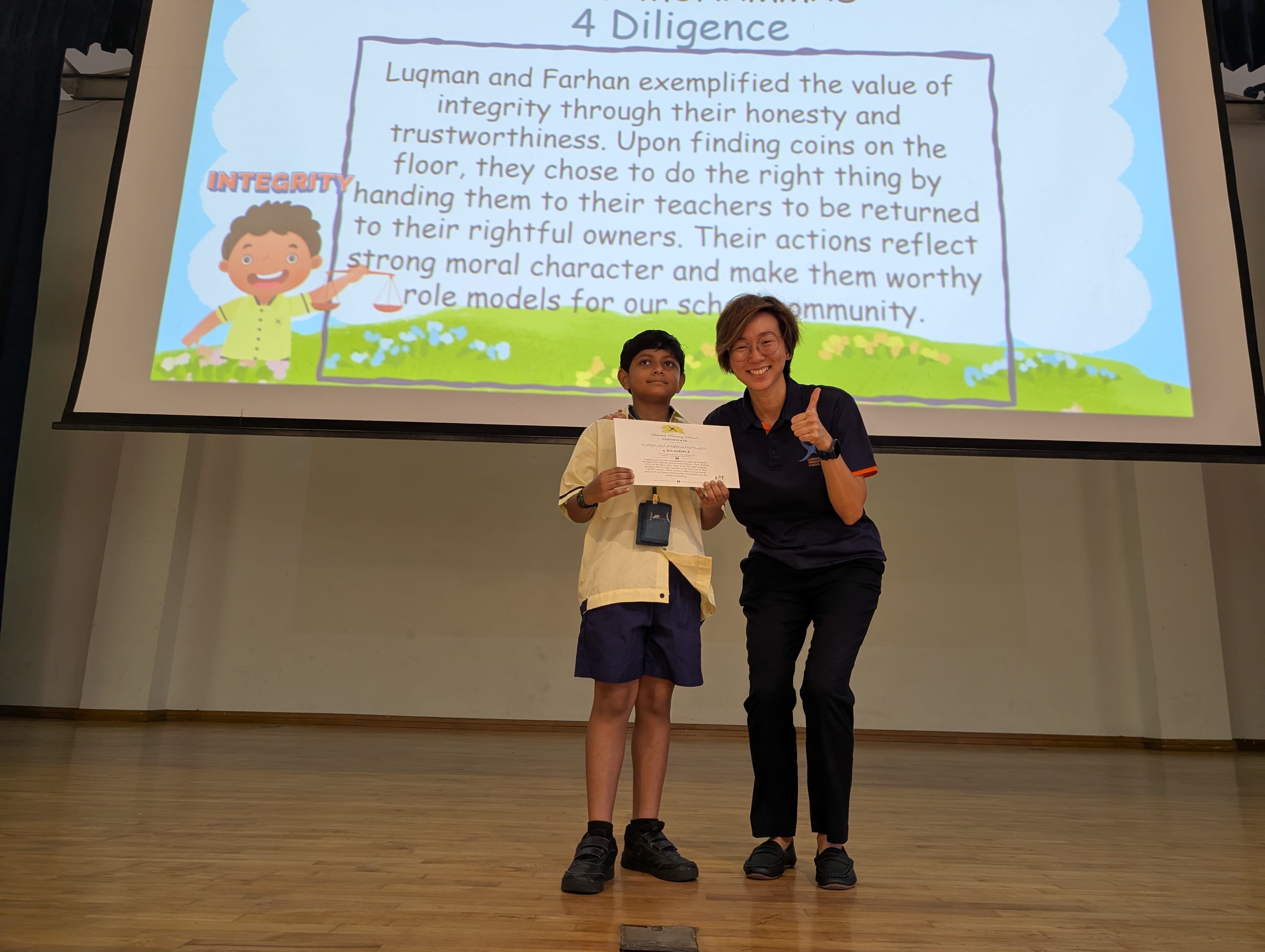 A boy receiving a certificate on the stage.